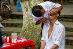 Dental procedure in street at the main road market, driving to Liping by Marie Anna Lee