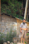 Man standing outside of brick house in Liping by Marie Anna Lee