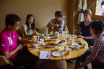 Wu Yunxia, performer in Kam professional choir with Zhang Zhanxian, her husband and others eating. by Marie Anna Lee