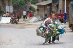 Woman carrying a lot of items in Liping by Marie Anna Lee