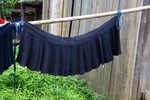 Pleated skirts hung on pole by Marie Anna Lee