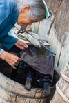 Wu Meitz dyes fabric in indigo vat