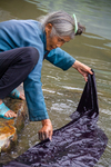 Wu Meitz washes fabric in river