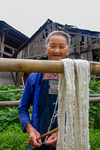 Woman untangling cotton threads on a skein by Marie Anna Lee