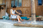Woman weaving flower belt by Marie Anna Lee