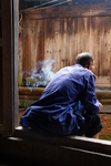 Man smoking on a doorstep by Marie Anna Lee