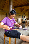 Wu Liangming weaving a flower belt on backstrap loom by Marie Anna Lee