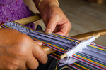 Wu Liangming weaving a flower belt on backstrap loom