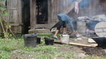 Adds pulp and water into the largest bucket by Marie Anna Lee