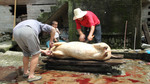 Preparing slaughtered pig by Marie Anna Lee