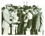 Baseball-Players and coaches being presented with trophy by U.S. Marine Corps
