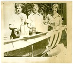 Rowing-University of the Pacific students next to boat and trophies by unknown