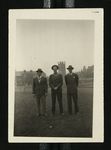 Football-Three men on field with University of Chicago buildings in background by W.F. Hodges Photos
