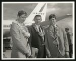 Football-Two unidentified players and coach in front of United Airlines plane by unknown