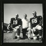 Football-Two unidentified players and coach on field by unknown