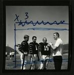 Football-Three unidentified players with coach Doug Scovil by unknown