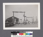 Children on playground swings by Richard Shizuo Yoshikawa