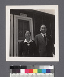 Man & woman in front of building [19-3-E]: Misaho and Nisuke Yoshikawa
