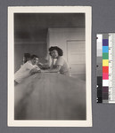 Man & woman leaning on counter by Richard Shizuo Yoshikawa