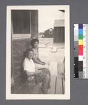 Man & woman seated on porch #1