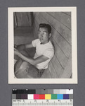 One man #26 [seated on porch; leaning against wall] by Richard Shizuo Yoshikawa