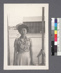 One woman #37 [standing on porch facing building; photo taken from inside] by Richard Shizuo Yoshikawa
