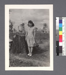 One woman #54 [standing beside stump]